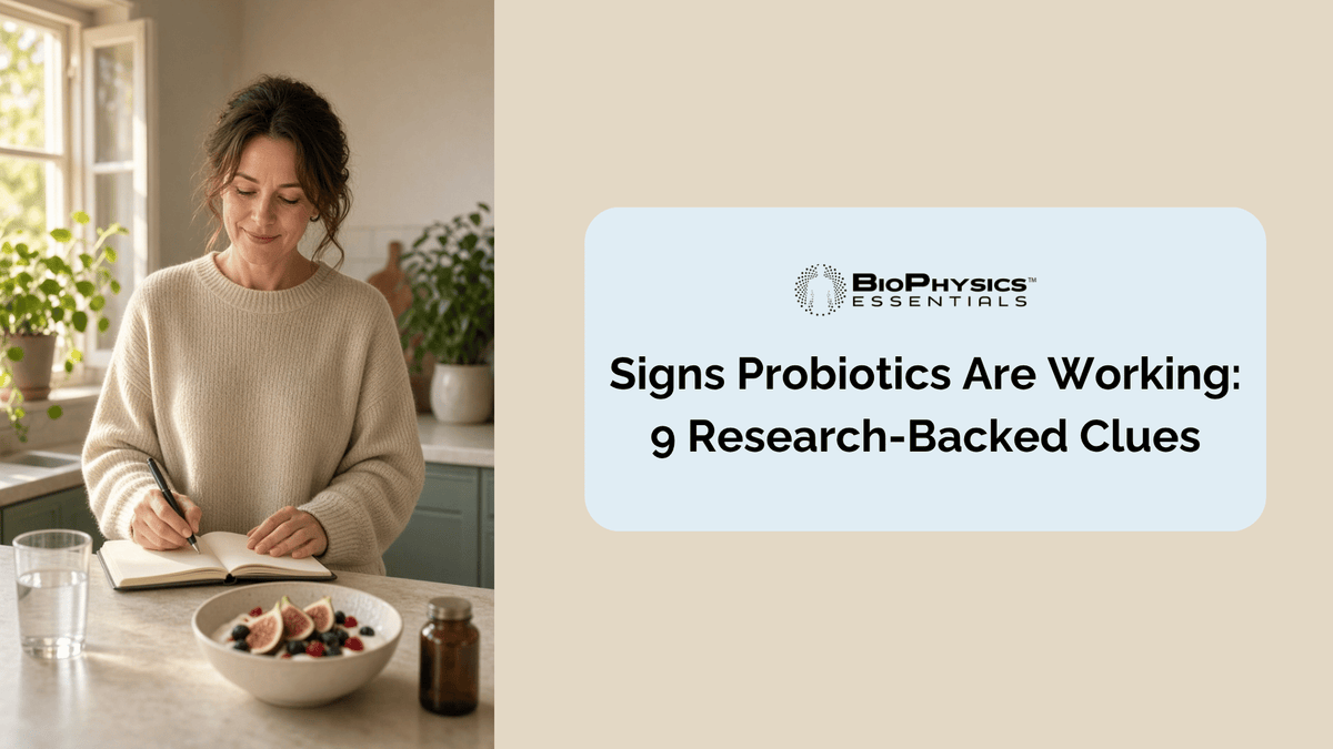 Woman in her early 40s standing at a sunlit kitchen counter in the morning, writing signs a probiotic is working in a small journal