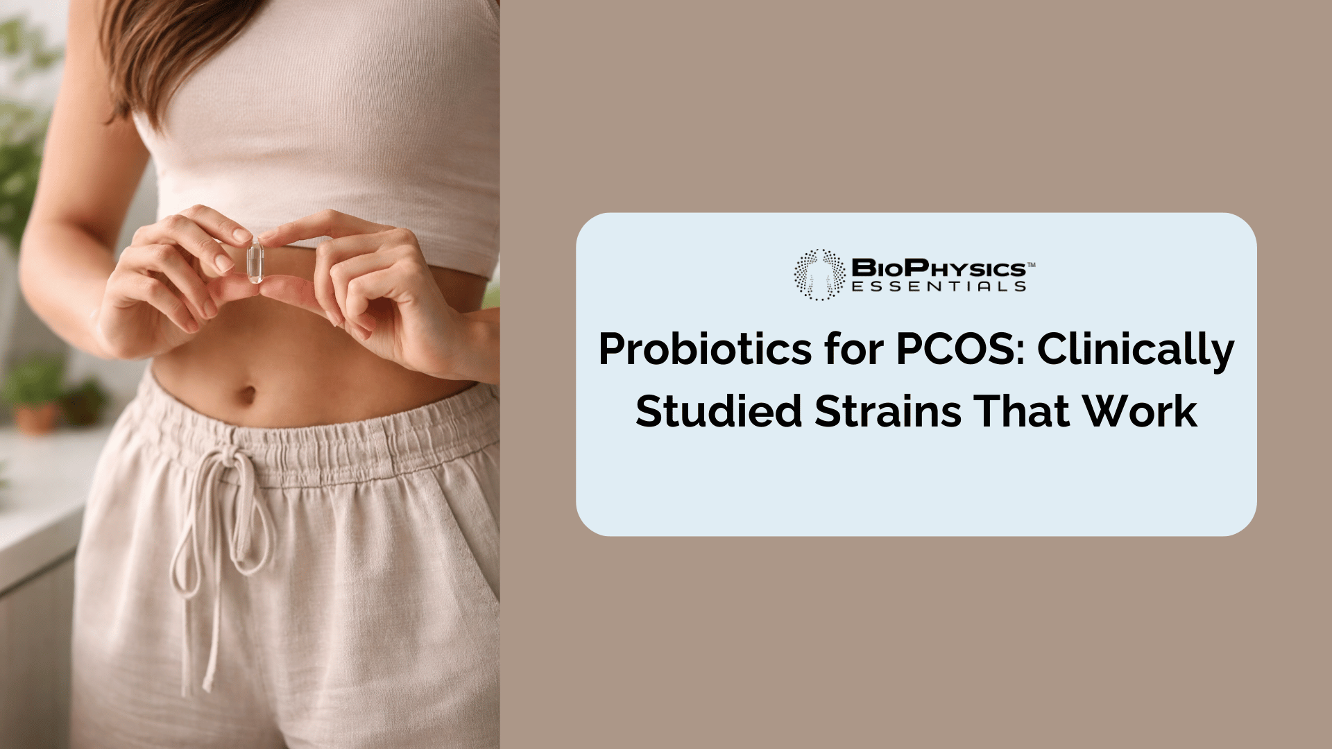 Woman holding a clear probiotic supplement capsule near her abdomen in warm natural lighting, representing gut health support for hormonal balance